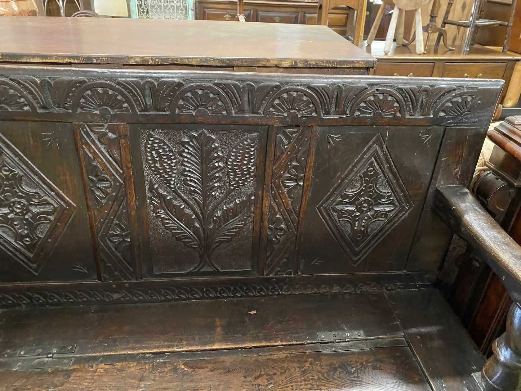 An 18th century carved oak box seat settle incorporating old timber, length 120cm, depth 44cm, height 101cm